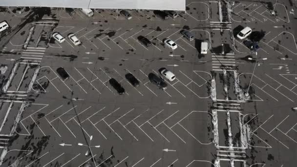 De auto beweegt zich door een lege parkeerplaats met veel lege parkeerplaatsen - luchtfoto drone — Stockvideo