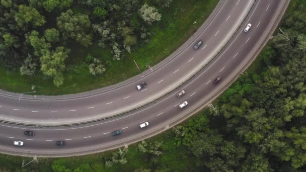 Tráfico en un tramo de carretera curva en un giro prolongado - tiro drone vista superior — Vídeo de stock