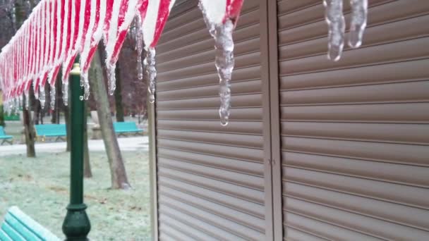 Icicles tát na střeše uzavřeného pouličního obchodu během jarního uzamčení v Charkově — Stock video