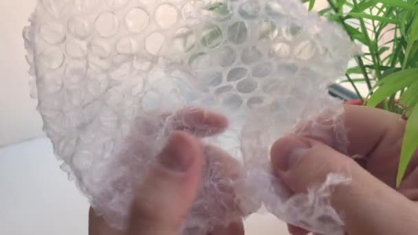Δάχτυλα σκάσει φυσαλίδες σε φούσκα πλαστική συσκευασία close-up — Αρχείο Βίντεο