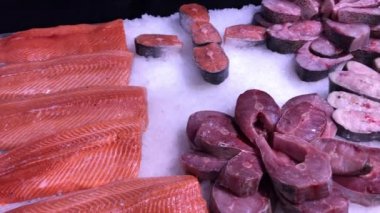 Tezgahta bir sürü balık Dorado ve Seabass var. Tezgahta kırmızı balık bifteği satılıyor.