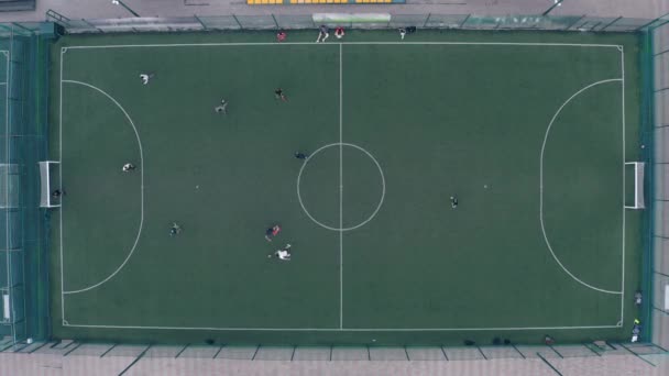 Spelare spelar fotboll på en grön fotbollsplan med vita markeringar — Stockvideo