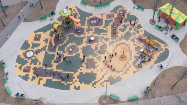 Kinder spielen auf dem Spielplatz mit Schaukeln, Karussells und Achterbahnen - Luftaufnahme — Stockvideo