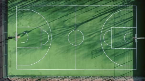 Leerer grüner Basketballplatz am Morgen mit schönen weichen Schatten - Luftaufnahme von oben — Stockvideo