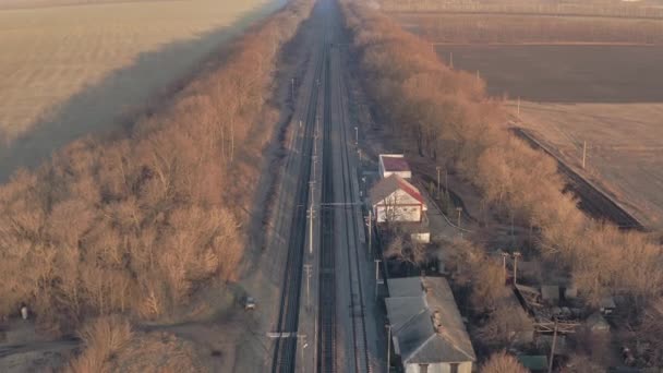 Pequeña estación de tren vacía con rieles y edificios pequeños - inclinación revelan tiro de dron — Vídeos de Stock