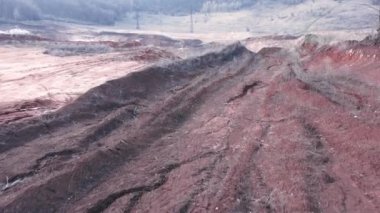 FPV insansız hava aracı bir kil ocağı üzerinde uçuyor, kırmızı çamur kayması..