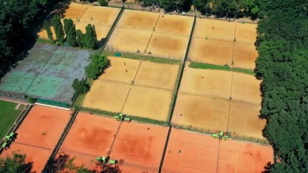 Treinamento de tênis e tênis nos tribunais, Hidratar quadras de tênis de barro - timelapse aérea — Vídeo de Stock