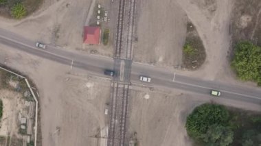 Arabalar demiryolu geçidini hareket ettiriyor, havadan çekim yapılıyor.