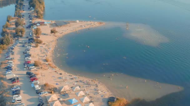 Множество отдыхающих на пляже в голубой лазурной лагуне, вид с воздуха — стоковое видео