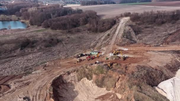 Matériel de construction : pelles et bulldozers se tiennent sur le sol près de la carrière de sable — Video