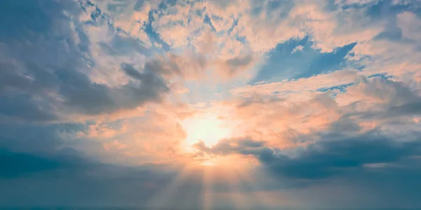 Sonniger Abend. Sonne am Horizont und gelbe Wolken am blauen Himmel — Stockfoto