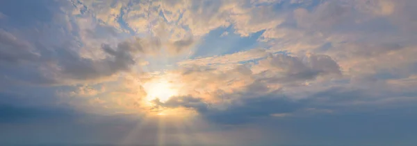 Solen i den blå himlen med moln. Strålarna skiner genom molnen. Panoramabilder. — Stockfoto