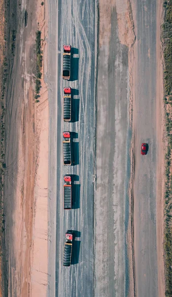 Convoy de camiones que conducen por carretera asfaltada con un coche rojo en el otro lado de la carretera — Foto de Stock