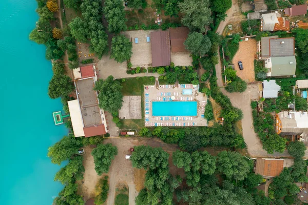 Luxury real estate on the shore of a azure pond, top view drone shot