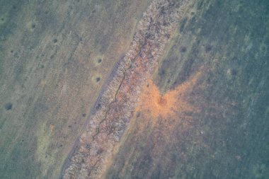 Savunma siperlerinin yanındaki ağır bir FAB hava bombasından oluşan büyük bir patlama izinin hava insansız hava aracı atışı. Patlama bölgesinin yukarıdan görünüşü, turuncu kazılmış toprağı gösteriyor. Ukrayna 'da askeri tahkim.