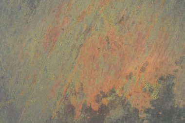 Pas turuncu, gri ve sarı liken benzeri lekelerden oluşan yüksek çözünürlüklü bir jeolojik yüzey. Soyut doğal grunge arka plan ve kaba karasal doku. Hava aracı görüntüsü.