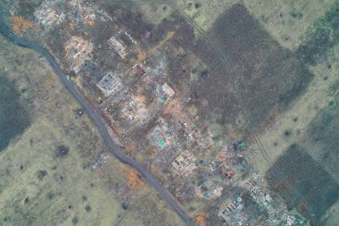 Yıkılmış bir köyün içinden geçen dolambaçlı bir yol yıkılmış evleri ve dağınık molozları ayırıyor. Bu hava görüntüsü yıkımın yolunu ve yerel topluluklar üzerindeki şiddetli sonuçları gösteriyor..