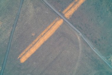 Derin tanksavar hendeklerinin yolları kestiği stratejik bir kavşağın yukarıdan aşağıya havadan görüntüsü. Bu savunma sistemleri, zırhlı araçların savaş alanında ilerlemesini engellemek için tasarlanmış geçilemez bariyerler görevi görüyor..