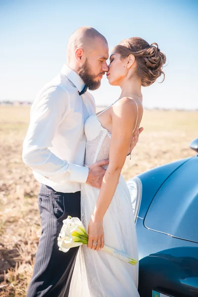 Pasgetrouwden in de buurt van hun auto — Stockfoto