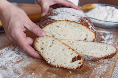 Mutfaktaki bir tahtanın üzerinde süt ve kurabiyeyle kokulu ve çıtır çıtır ekmek. Ev yapımı taze ekmek. Yuvarlak ev yapımı ekmek..