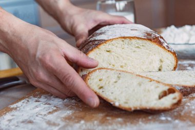 Mutfaktaki bir tahtanın üzerinde süt ve kurabiyeyle kokulu ve çıtır çıtır ekmek. Ev yapımı taze ekmek. Yuvarlak ev yapımı ekmek..