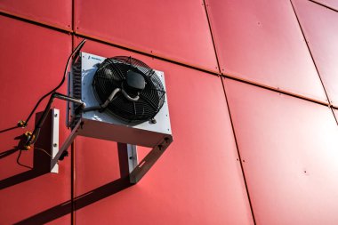 Evin duvarında klima var. Kırmızı ev. Havalandırma sistemi.