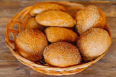 Hamburger, sandviç, susamlı çörek, çörek. Tahta arka planda susam tohumlu taze hamburger ekmeği. Lezzetli hamburger çörekleri.