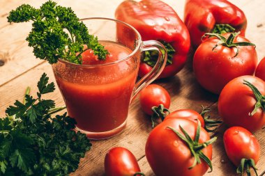 Ahşap bir masada kırmızı biber ve taze domates. Tuzlu domates suyu..