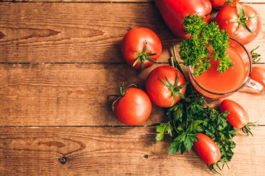 Ahşap bir masada kırmızı biber ve taze domates. Tuzlu domates suyu..