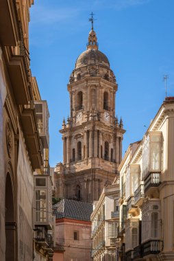 Endülüs, İspanya 'nın göbeğinde klasik İspanyol mimarisi ve mavi gökyüzü ile büyüleyici dar bir sokaktan Malaga Katedrali' nin çan kulesinin yakın görüntüsü..