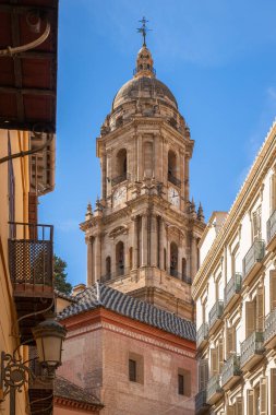 Endülüs, İspanya 'nın göbeğinde klasik İspanyol mimarisi ve mavi gökyüzü ile büyüleyici dar bir sokaktan Malaga Katedrali' nin çan kulesinin yakın görüntüsü..
