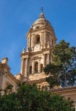 Endülüs, İspanya 'nın göbeğinde klasik İspanyol mimarisi ve mavi gökyüzü ile büyüleyici dar bir sokaktan Malaga Katedrali' nin çan kulesinin yakın görüntüsü..