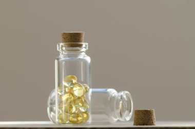 İki şeffaf tıbbi şişe gri bir arka plan üzerinde