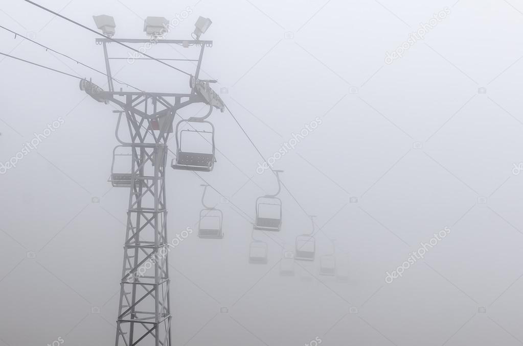 Chairlift vanishing into fog