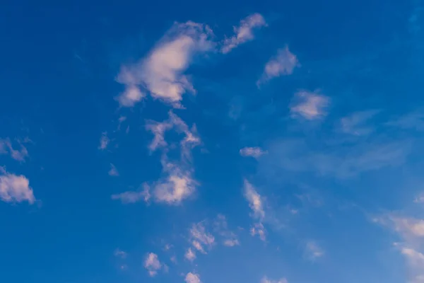 landscape of clouds in late day sky, golden sunlight reflecting on the nuves in blue sky