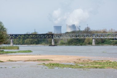 Nehir bir köprü ve arka planda bir elektrik santrali