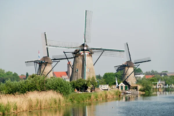 Tre mulini a vento olandesi sulla riva di un canale — Foto Stock