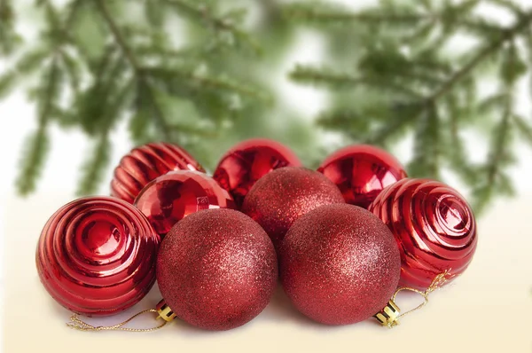 Bolas rojas de Navidad sobre la mesa con un árbol de Navidad —  Fotos de Stock