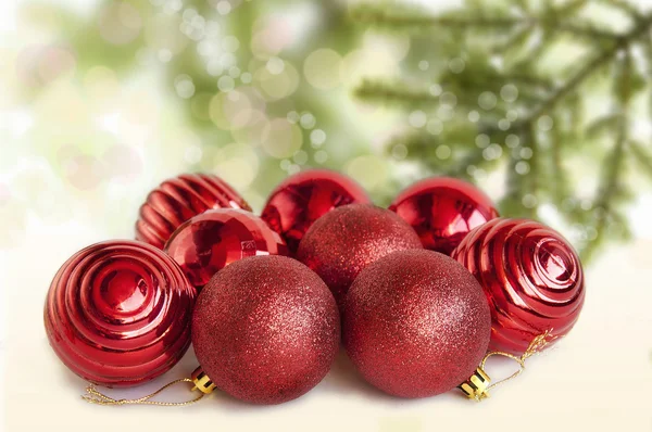Bolas rojas de Navidad sobre la mesa con un árbol de Navidad —  Fotos de Stock