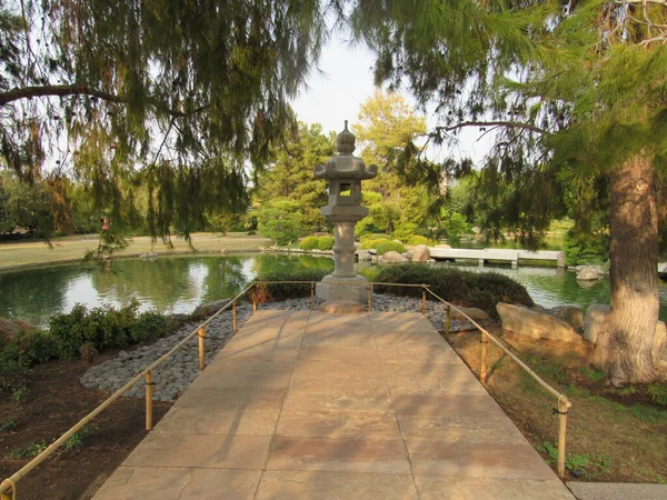 Kamienna Rzeźba Spokojnym Japońskim Ogrodzie Drzewami Roślinami Koi Staw Rybny — Zdjęcie stockowe