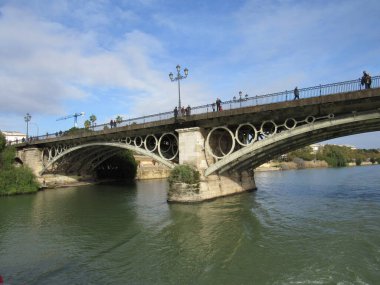 Puente de Isabel II olarak da bilinen Triana Köprüsü Seville, İspanya 'da bir teknenin arkasında görüldü.