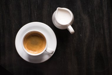 ahşap masa üstünde kremalı kahve fincanı