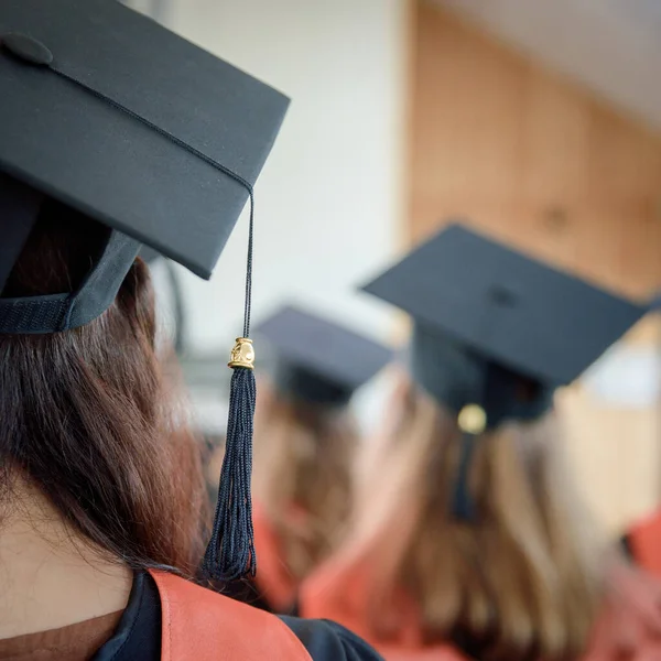 Women graduates of the university in square academic caps during graduation ceremony. Congratulation concept for graduates of university.