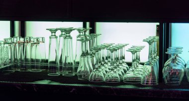 Boş, yıkanmış ve parlatılmış bardaklar açık arkaplanda bir bar tezgahında.