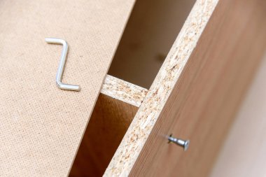 Tahta mobilya montajı sırasında vida veya alçıpan görüntüsü. Ev onarım konseptleri. Orta yoğunluklu fiber ahşap ürün. Mobilya fikirleri.