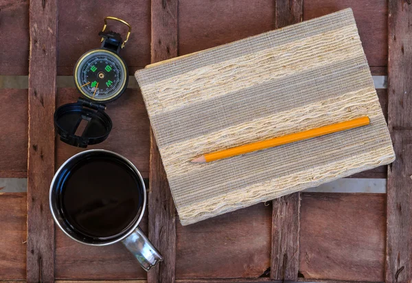 Xícara de café com bússola e bloco de notas — Fotografia de Stock