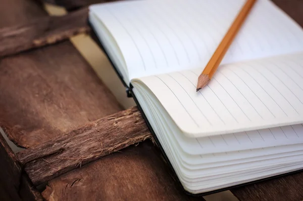 Notepad with pen on wood table — Stock Photo, Image