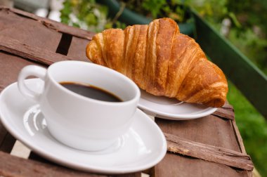 Bir fincan kruvasanla kahve.