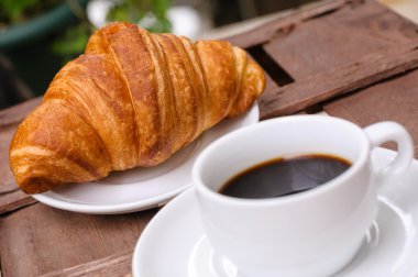 Bir fincan kruvasanla kahve.