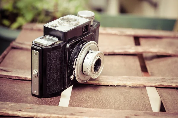 Câmera retro em fundo de madeira — Fotografia de Stock